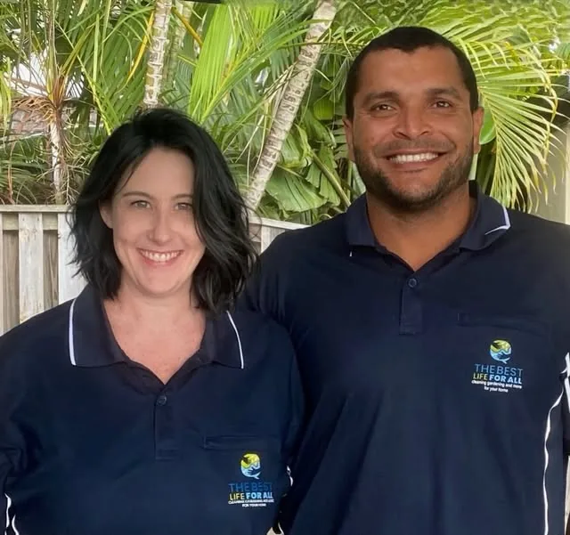 Julia and Esteban smiling in their navy The Best Life For All work shirts